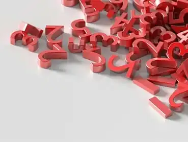 A scattered pile of red and white 3D-rendered punctuation marks, including question marks, exclamation points, and ampersands, on a flat, light gray surface.