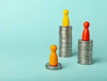 Three stacks of coins with different heights on a blue background, each topped by a colored game piece. The shortest stack has an orange game piece, the medium stack has a yellow game piece, and the tallest stack has a red game piece.