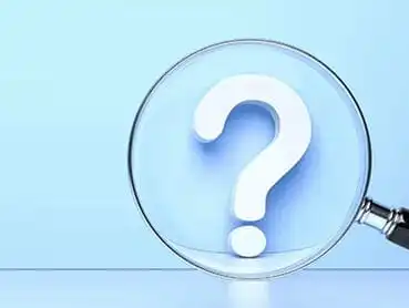 A large white question mark is viewed through a magnifying glass against a light blue background. The magnifying glass handle is partially visible on the right side of the image.